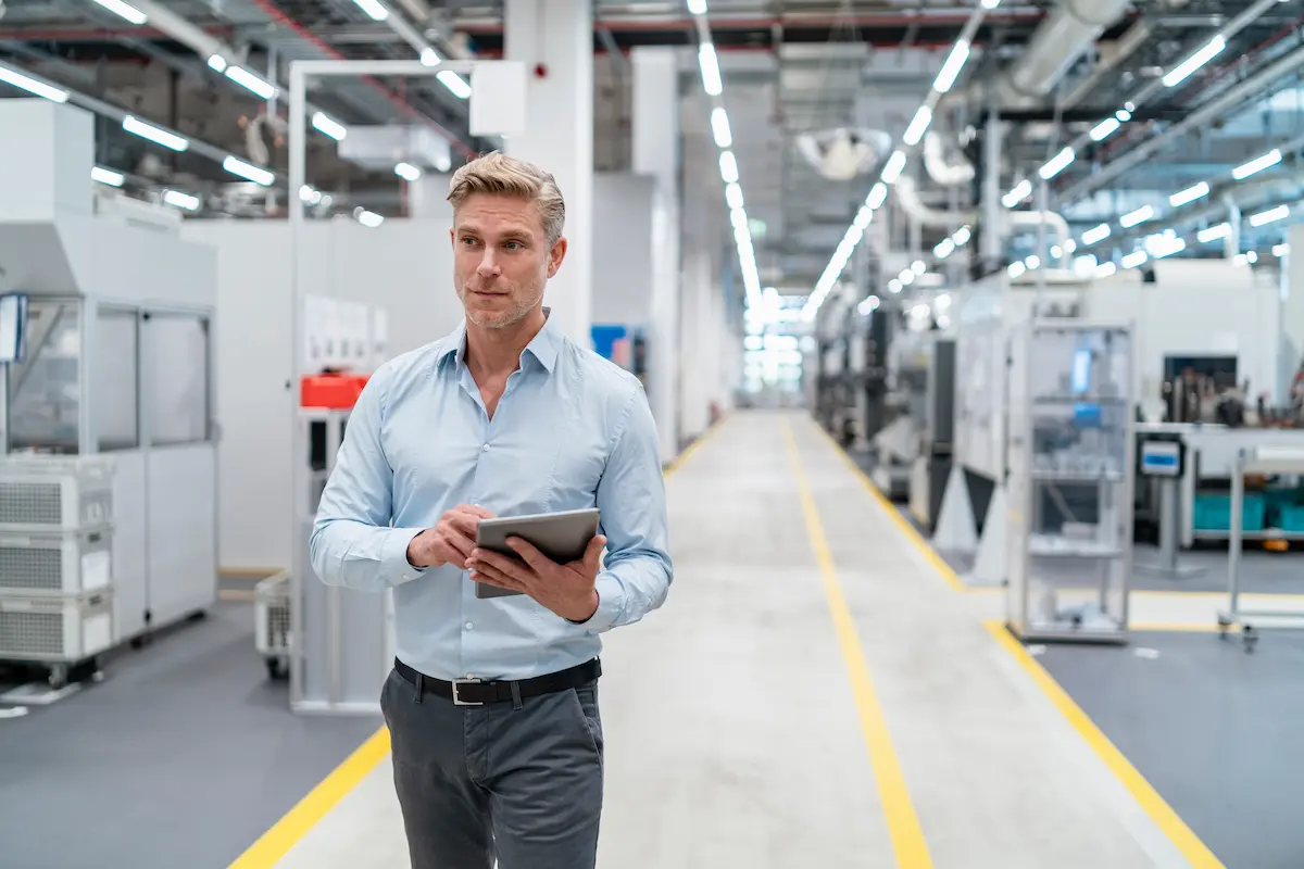 Mann mit Tablet läuft in einer Industrie herum